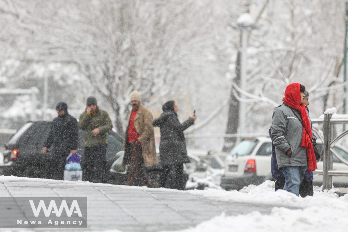 People walk during a snowfall in a street in Teheran, Iran/WANA (West Asia News Agency)
