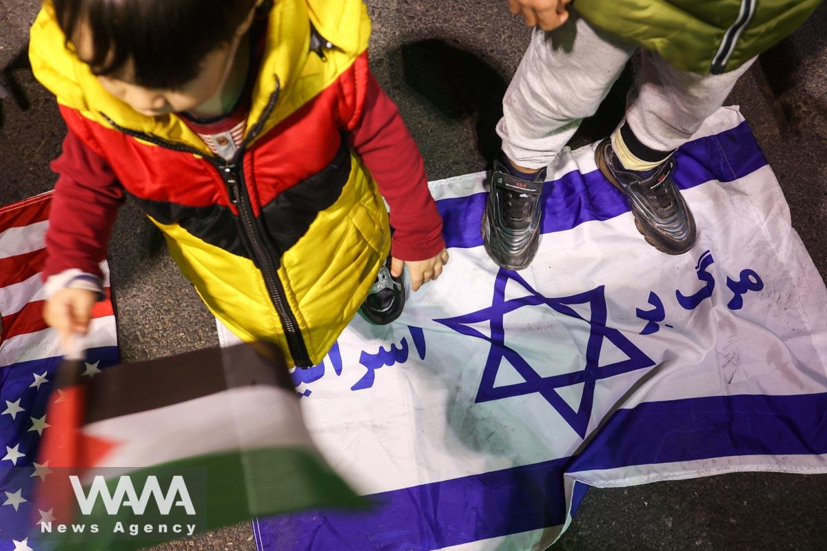 An Iranian child stands on the Israeli flag during an anti-Israel protest