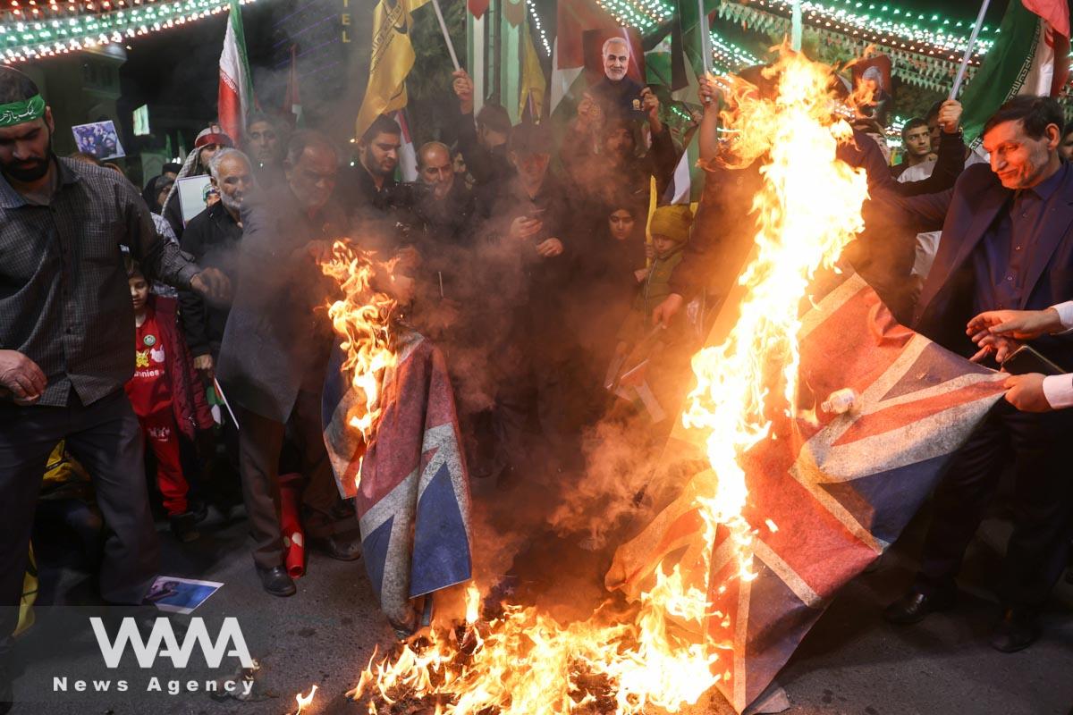 Protesters burn the British flag during an anti-Israel protest