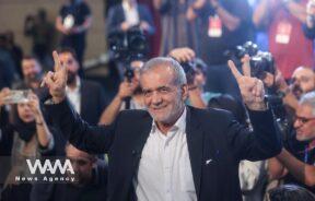 Presidential candidate Masoud Pezeshkian shows the victory sign during a campaign event