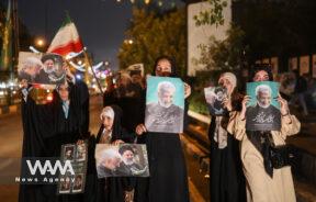 Supporters of Iranian presidential candidate Saeed Jalili hold posters of him on a street in Tehran