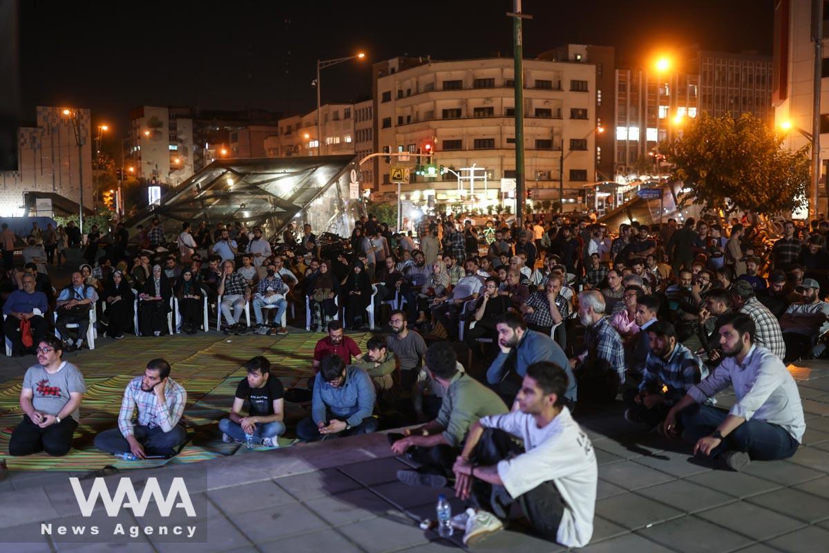 People watch the debate of presidential candidates at a park