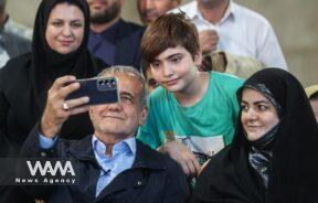 Presidential candidate Masoud Pezeshkian takes a selfie with one of his supporters during a campaign gathering