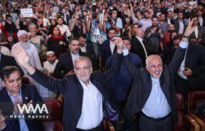 Presidential candidate Masoud Pezeshkian and former Foreign Minister Mohammad Javad Zarif show the victory sign during a campaign event