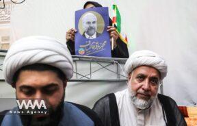 A supporter of presidential candidate Mohammad Bagher Ghalibaf holds a poster of him during a campaign event