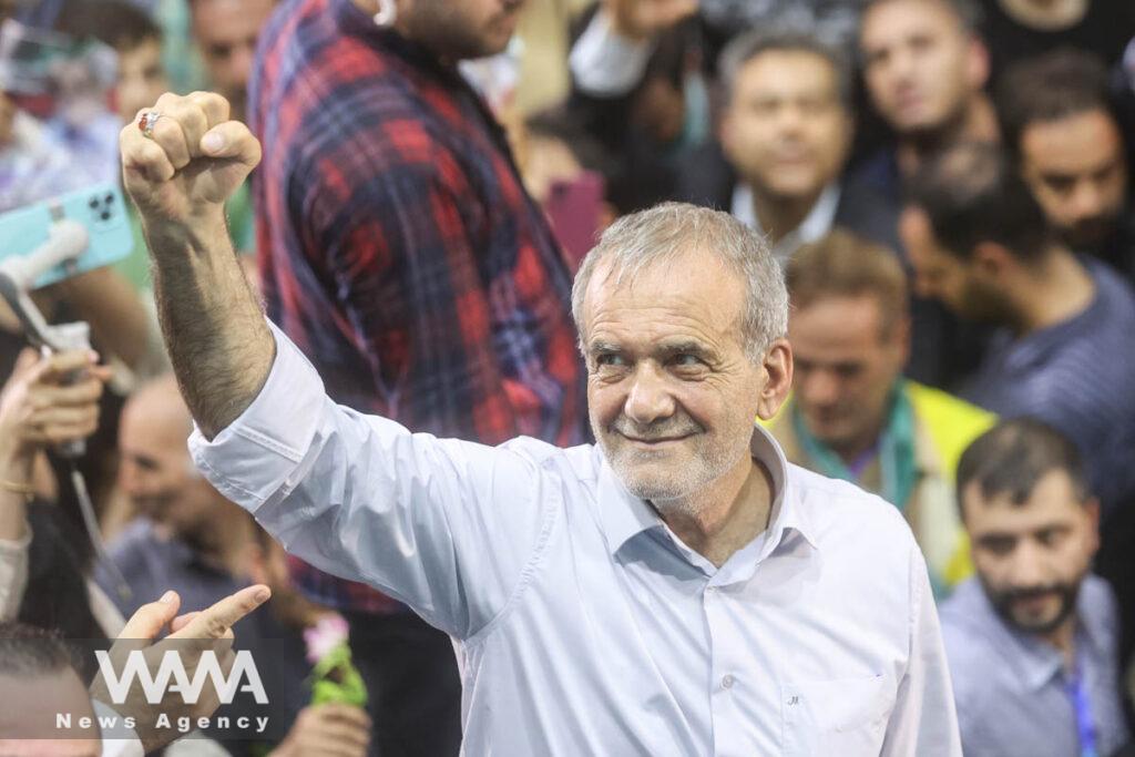 Iranian presidential candidate Masoud Pezeshkian waves during a campaign event