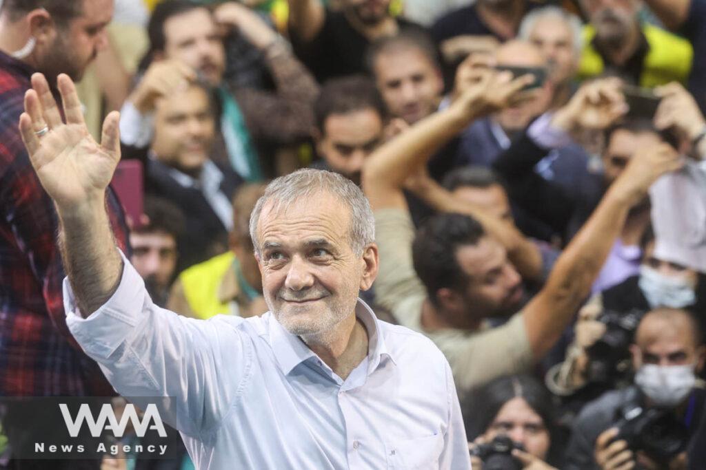 Iranian presidential candidate Masoud Pezeshkian waves during a campaign event