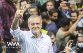 Presidential candidate Masoud Pezeshkian shows the victory sign during a campaign event