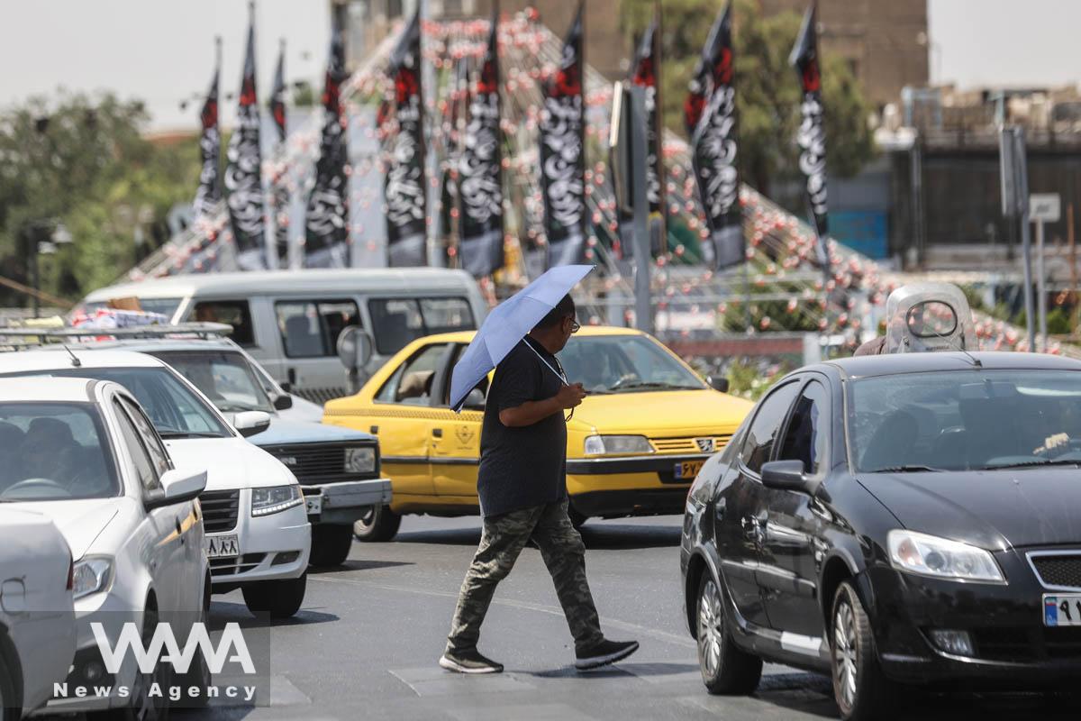 An Iranian man walks in a street during the heat surge in Tehran