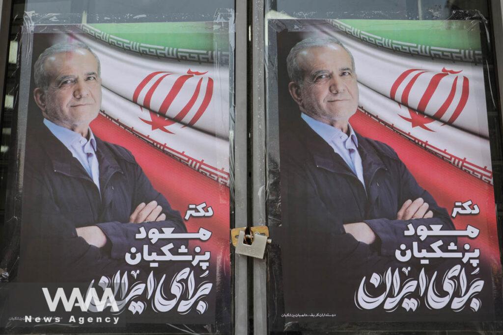 A poster of presidential candidate Masoud Pezeshkian is displayed on a street in Tehran