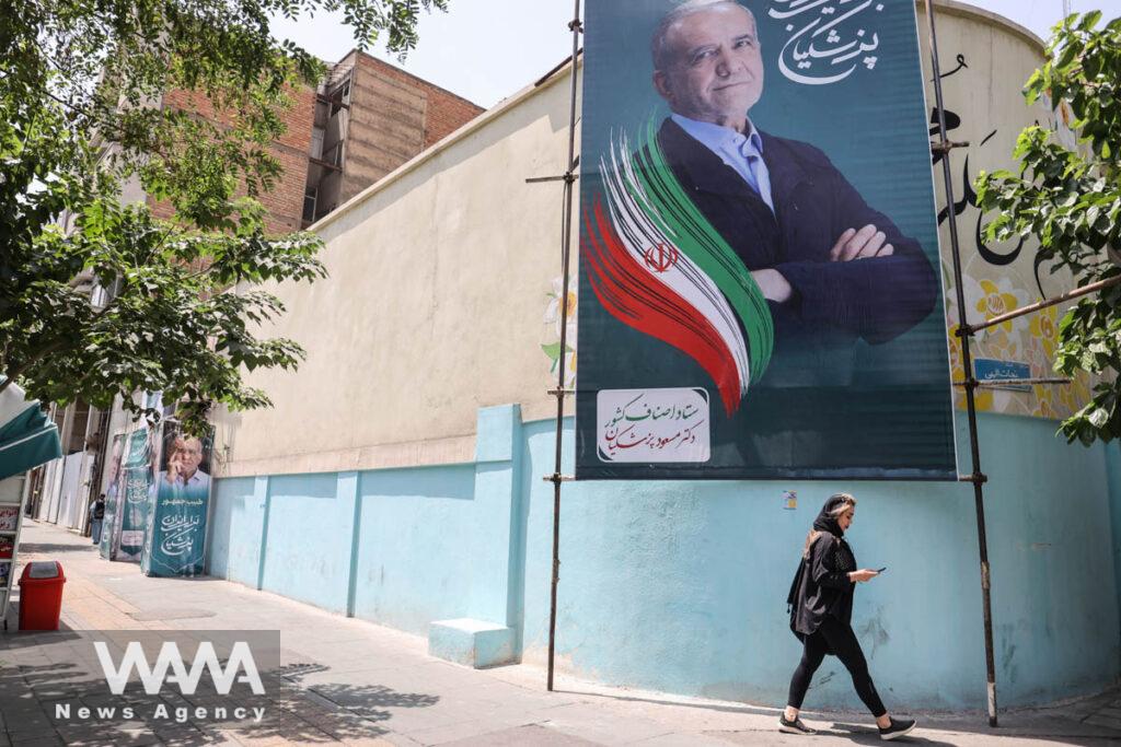 A banner of presidential candidate Masoud Pezeshkian is displayed in a street in Tehran