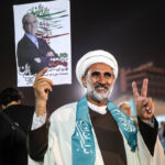 A supporter holds a poster of Iranian presidential candidate Masoud Pezeshkian during a campaign event in Tehran