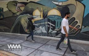 Iranians walk past an anti-Israel mural on a street in Tehran, Iran July 31, 2024. Majid Asgaripour/WANA (West Asia News Agency)