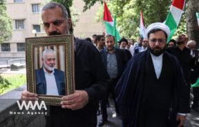 An Iranian man holds a picture of the Palestinian group Hamas' top leader Ismail Haniyeh, following the assassination of him, in Tehran, Iran July 31, 2024. Majid Asgaripour/WANA (West Asia News Agency)