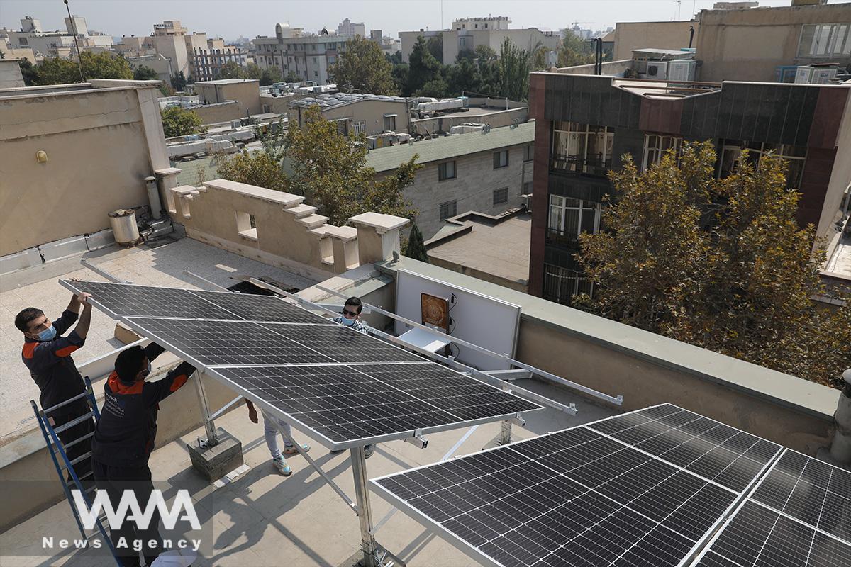 Technicians install solar panels on a residential rooftop in Tehran, Iran October 11, 2020. Picture taken October 11, 2020. Majid Asgaripour/WANA (West Asia News Agency)