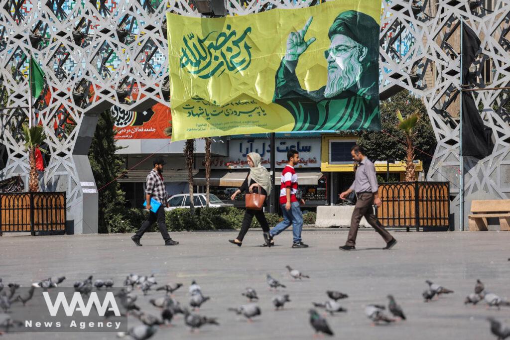 People walk past a billboard with a picture of the late Lebanon's Hezbollah leader Hassan Nasrallah, in a street