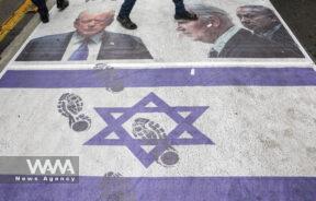 Iranians step on an Israeli flag and a banner with pictures of U.S. President Joe Biden and Israel's Prime Minister Benjamin Netanyahu and former U.S. President Donald Trump, during the 45th anniversary of the U.S. expulsion from Iran