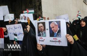 An Iranian woman holds a picture of Turkish President Recep Tayyip Erdogan and Israeli Prime Minister Benjamin Netanyahu during a gathering to protest against the Turkish government's claim of backing the Islamist militant group Hayat Tahrir al-Sham (HTS) outside of the Turkish Embassy in Tehran