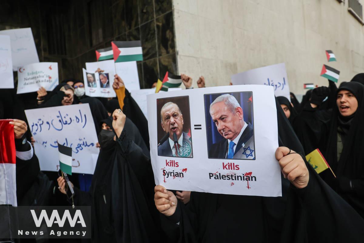 An Iranian woman holds a picture of Turkish President Recep Tayyip Erdogan and Israeli Prime Minister Benjamin Netanyahu during a gathering to protest against the Turkish government's claim of backing the Islamist militant group Hayat Tahrir al-Sham (HTS) outside of the Turkish Embassy in Tehran