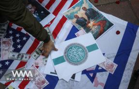 U.S dollar and Turkish lira bills are seen on the flags of Israel and the U.S during a gathering to protest against the Turkish government's claim of backing the Islamist militant group Hayat Tahrir al-Sham (HTS) outside of the Turkish Embassy in Tehran