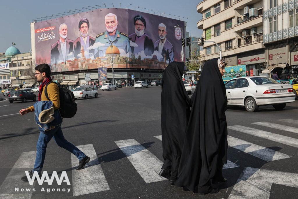 Iranians walk next to a billboard with a picture of late Hamas leader Ismail Haniyeh, senior Iranian military commander General Qassem Soleimani, late Lebanon's Hezbollah leader Sayyed Hassan Nasrallah and late Hamas leader Yahya Al-Sinwar on a street in Tehran, Iran, January 16, 2025. Majid Asgaripour/WANA (West Asia News Agency)